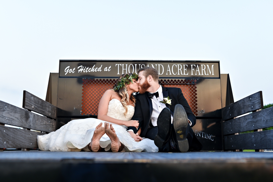 A bride and groom in the back of an old pickup truck